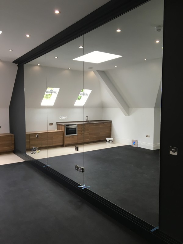 Frameless glass partition in loft conversion by Holloway glaziers